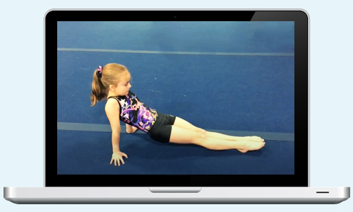 A laptop computer showing an AIM Gymnastics gymnast participating in a virtual class over Zoom. She is in a rear support strength position on the floor.